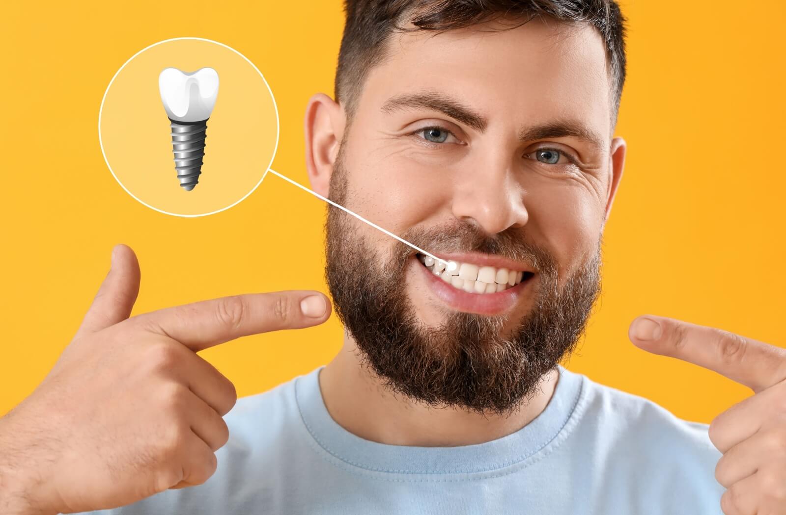 A person happily points to their tooth implant, their smile looking natural and healthy.